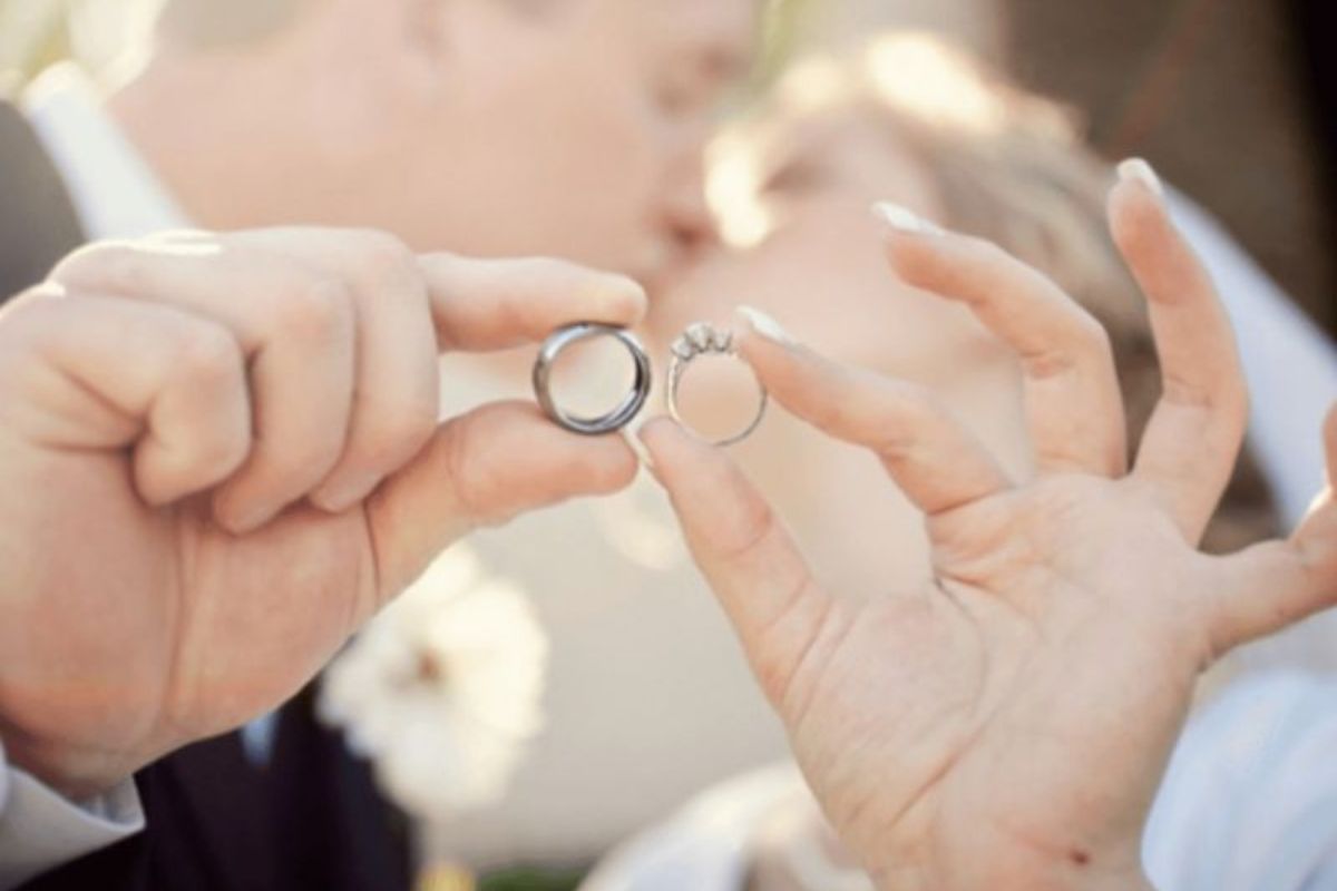 Cả hai cùng nắm tay nhau, để lộ nhẫn cưới, thể hiện sự gắn kết và tình yêu (Ảnh: Sưu tầm)
