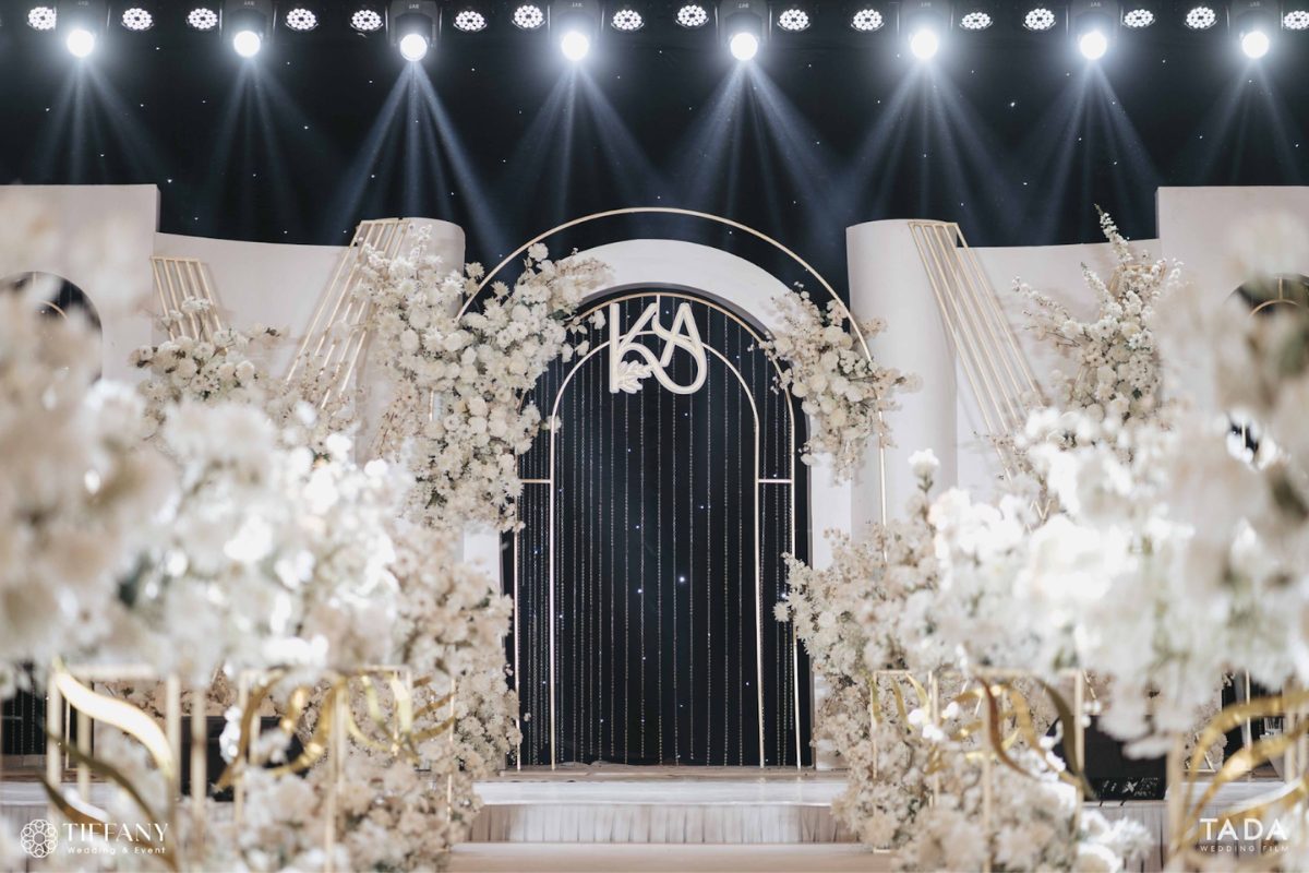 Không gian tiệc cưới sang trọng với backdrop trắng - đen, điểm nhấn là hoa trắng tinh khôi và chi tiết ánh kim nổi bật. (Ảnh: TIFF.vn)