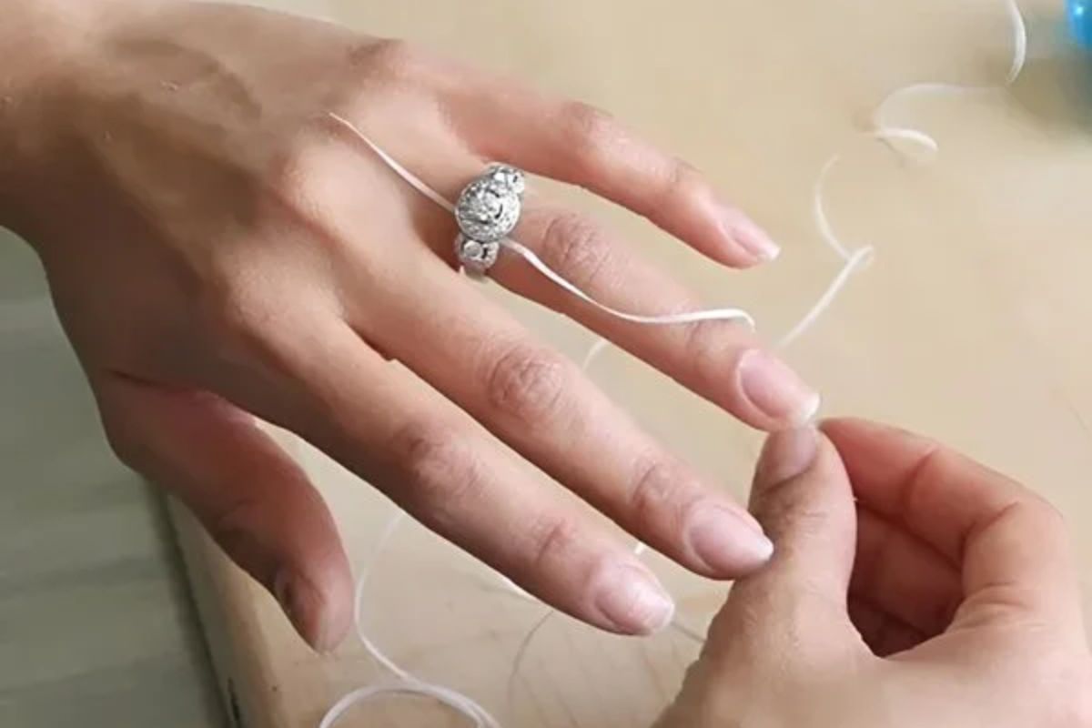 Một cách đơn giản và tạm thời là dùng sợi chỉ quấn vào mặt sau của nhẫn để thu hẹp kích thước (Ảnh: Sưu tầm)