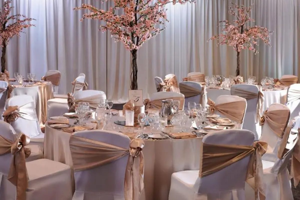 Ghế cưới sang trọng với khăn satin champagne và hoa trắng tinh khôi. (Ảnh: Sưu tầm)