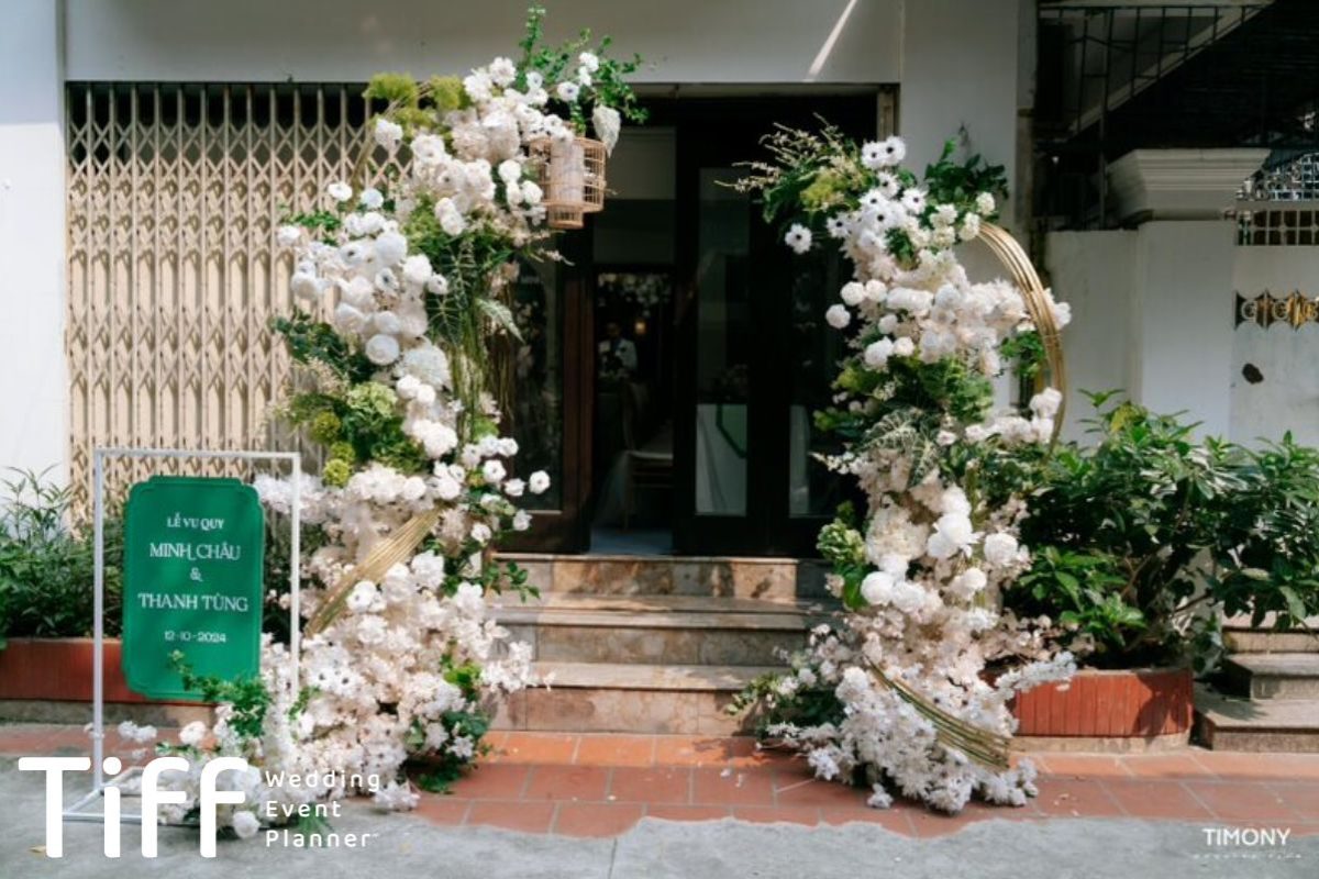 Cổng cưới trắng sang trọng với hoa tươi kết hợp khung tre cách điệu và lồng trang trí. (Ảnh: TIFF.vn)