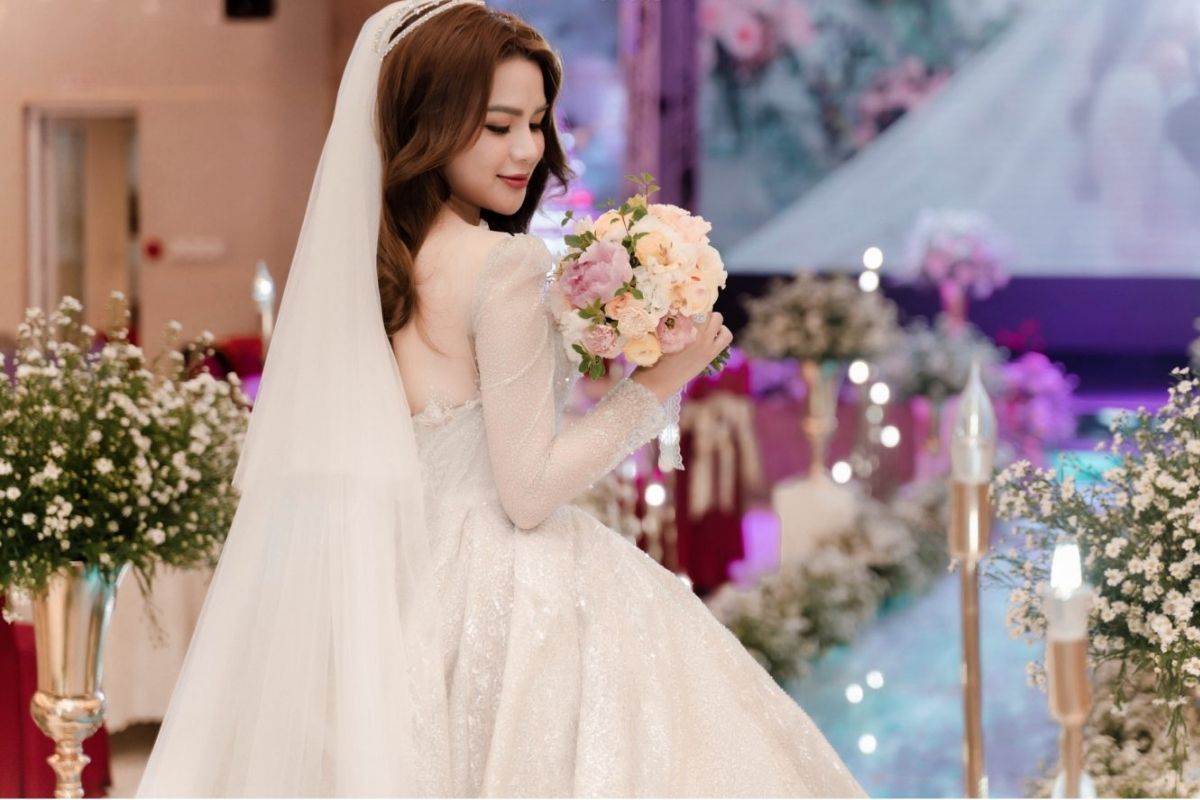Cầm hoa cưới đúng vị trí giúp cân đối trang phục (Ảnh: Sưu tầm)
