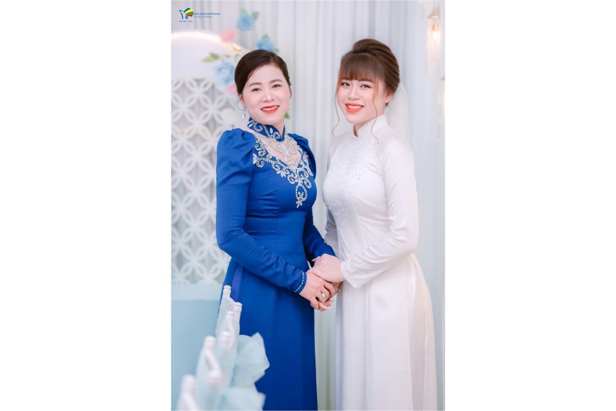 Tóc búi thấp thanh lịch tôn nét rạng rỡ cùng áo dài nhung xanh (Ảnh: Sưu tầm)