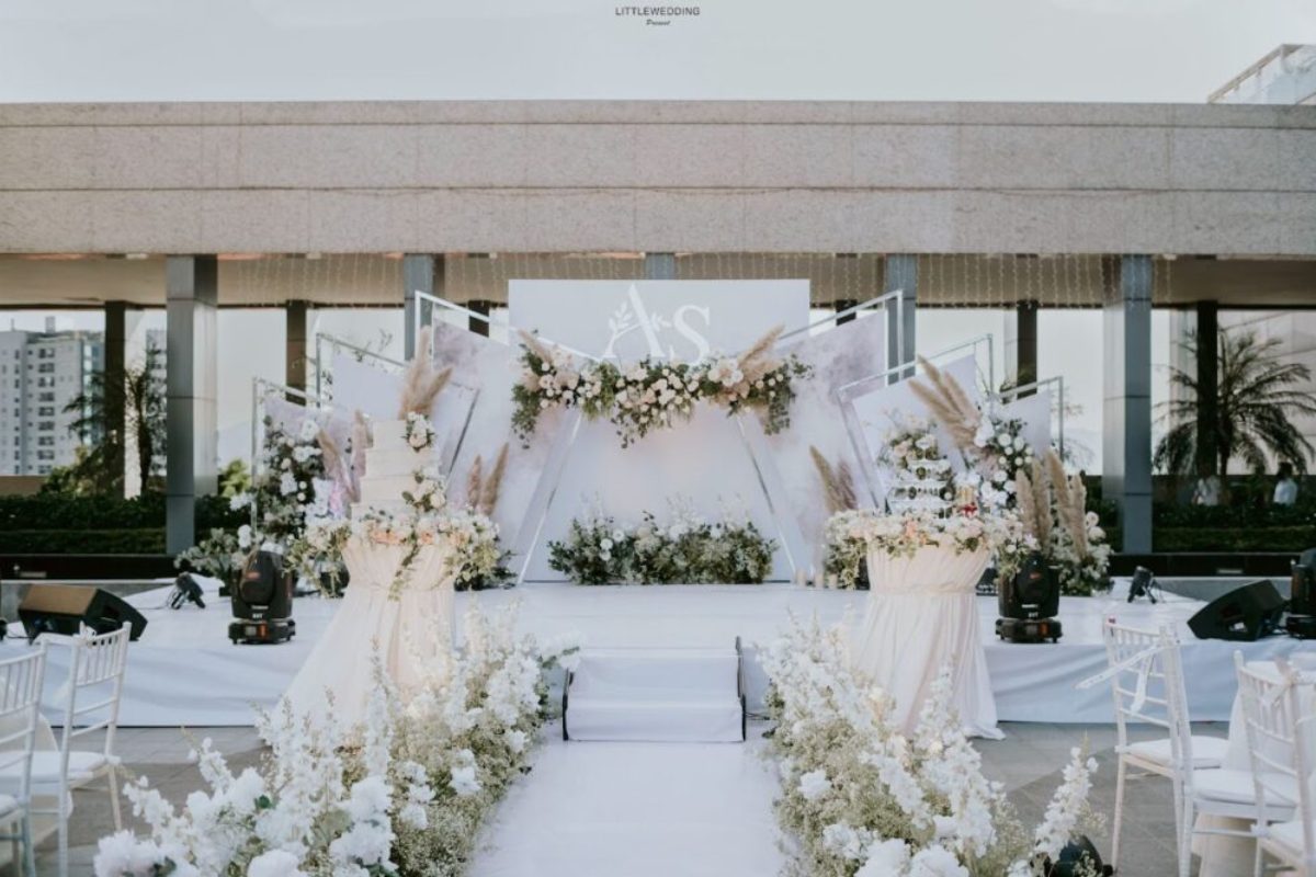 Sân khấu cưới tại nhà với background trắng và điểm nhấn hoa pastel nhẹ nhàng (Ảnh: Sưu tầm)