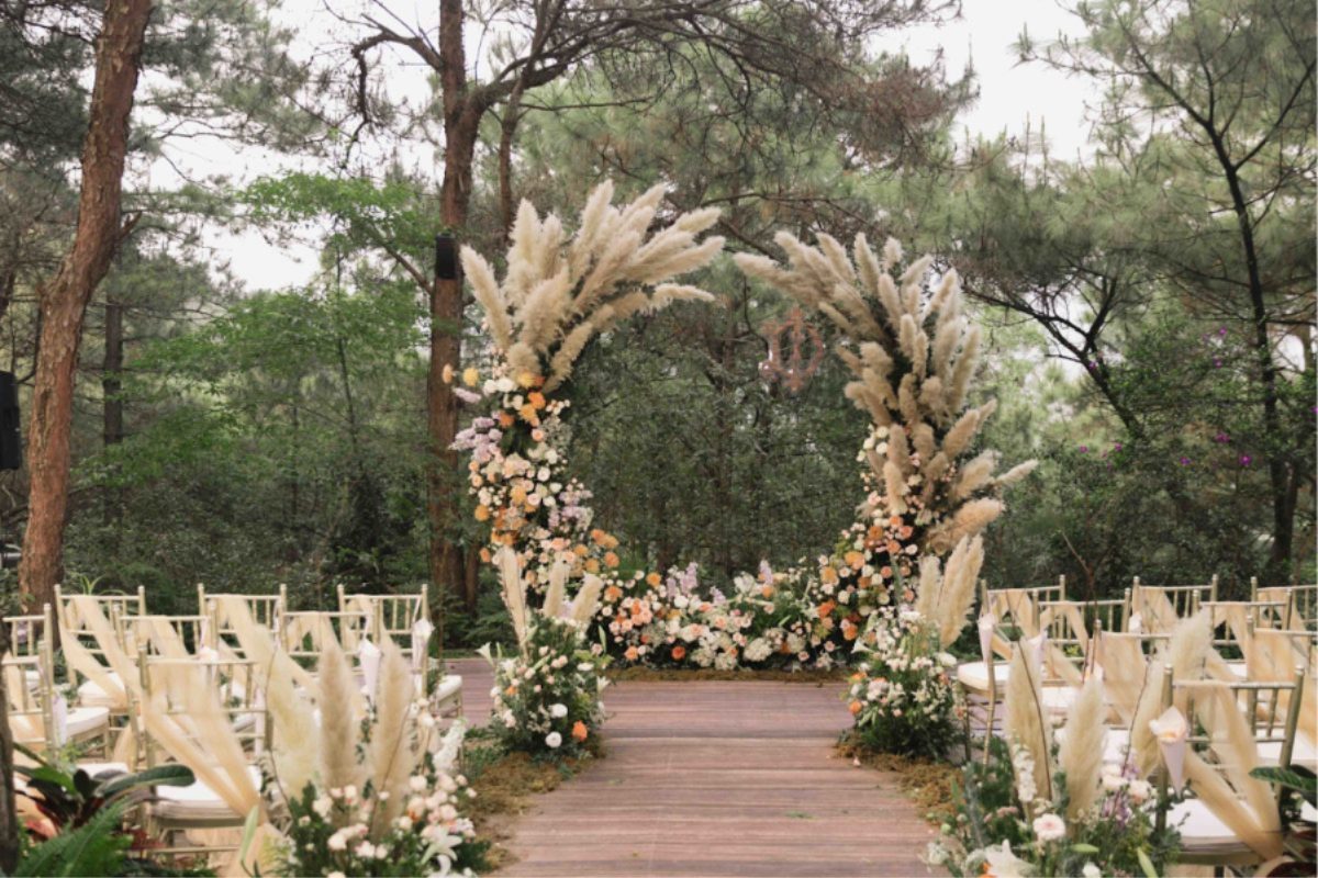 Trang trí đường dẫn lễ cưới theo địa điểm – ngoài trời với hoa cỏ và dây đèn, trong nhà sang trọng. (Ảnh: TIFF.vn)