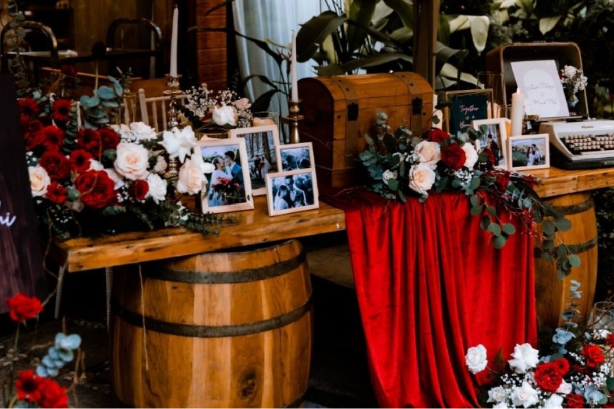 Bàn reception phối xanh emerald & đỏ burgundy, điểm xuyết nến vàng hoặc hoa đỏ burgundy. (Ảnh: Sưu tầm)