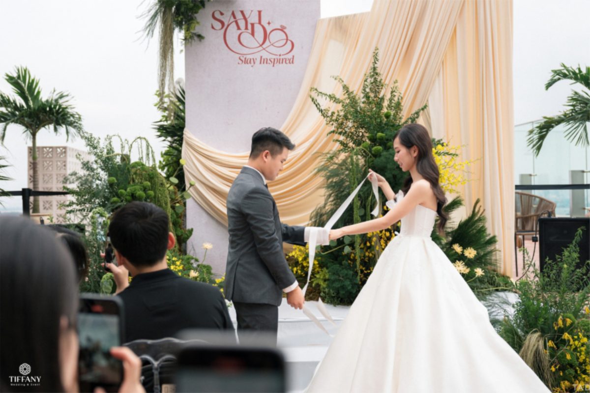 Cô dâu chú rể thực hiện nghi thức Handfasting, đôi tay được buộc lại bằng dải lụa như lời hẹn ước trọn đời. (Ảnh: TIFF.vn) 