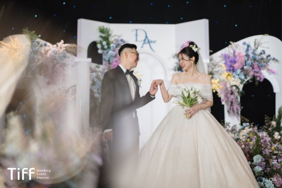 Cặp đôi thực hiện nghi thức cưới dưới ánh đèn vàng ấm, không gian lung linh và trang trọng (Ảnh: TIFF.vn) 