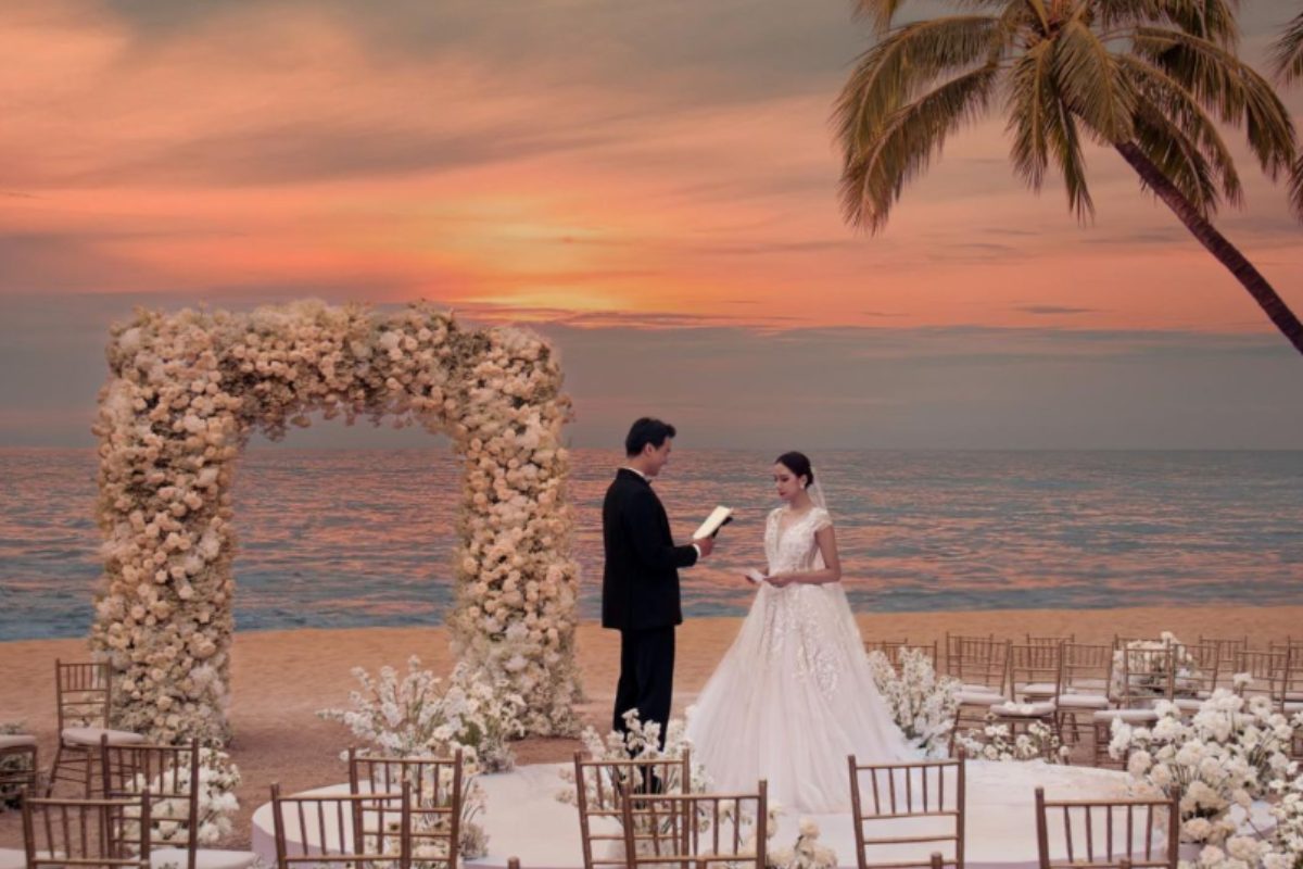 Tiệc cưới nhỏ bên bờ biển Phú Quốc, setup sang trọng với backdrop hoa tươi và ánh sáng hoàng hôn. (Ảnh: Sưu tầm)