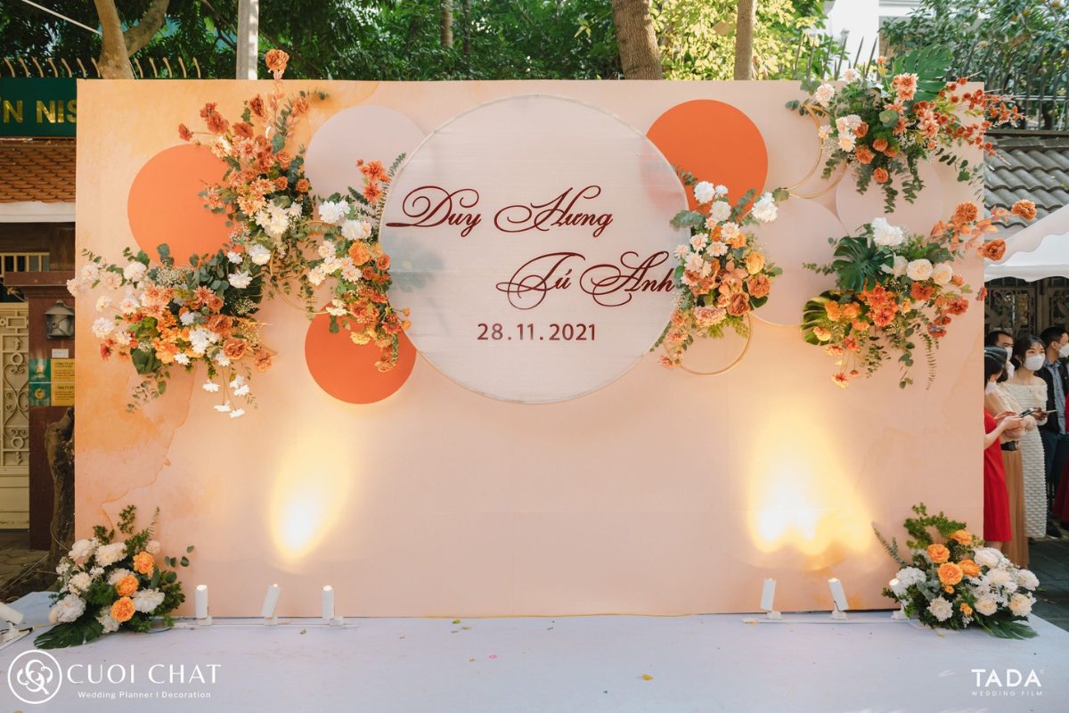 Backdrop chụp hình ngoài trời tone đỏ – cam rực rỡ, nổi bật, mang đến khung hình ấm áp và đầy năng lượng cho ngày cưới. (Ảnh: TIFF.vn)