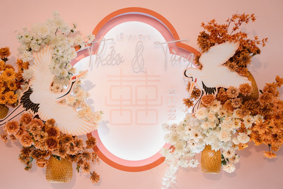 Backdrop đỏ – cam phối hoa cùng tông, tạo không gian rực rỡ, ấm áp và đầy lãng mạn cho lễ cưới. (Ảnh: TIFF.vn)