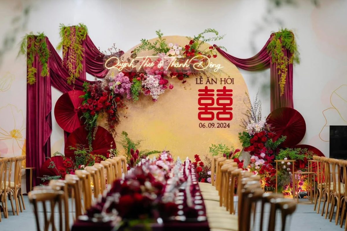 Backdrop lễ ăn hỏi sang trọng tone đỏ và be, trang trí hoa tươi đỏ, hồng, tím, kết hợp lá xanh, khăn drap burgundy ấn tượng. (Ảnh: Sưu tầm)