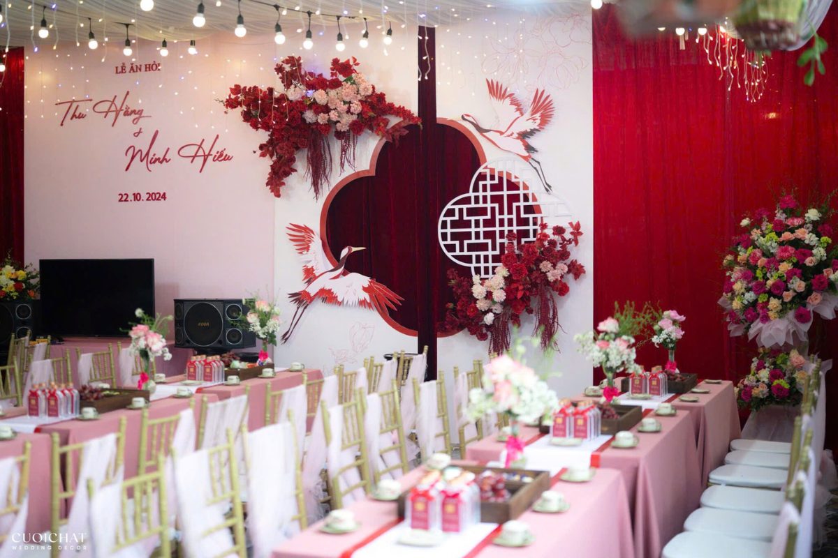Backdrop đỏ – trắng phối hợp hài hòa, tạo điểm nhấn nổi bật nhưng vẫn giữ sự dịu dàng cho ngày cưới. (Ảnh: TIFF.vn)