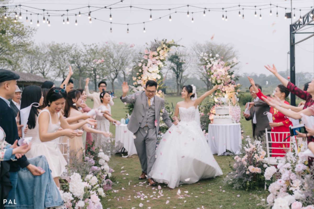 Tiệc cưới ngoài trời tại Nắng Sông Hồng với lối đi hoa tươi trắng tinh tế. (Ảnh: Nắng Sông Hồng) 