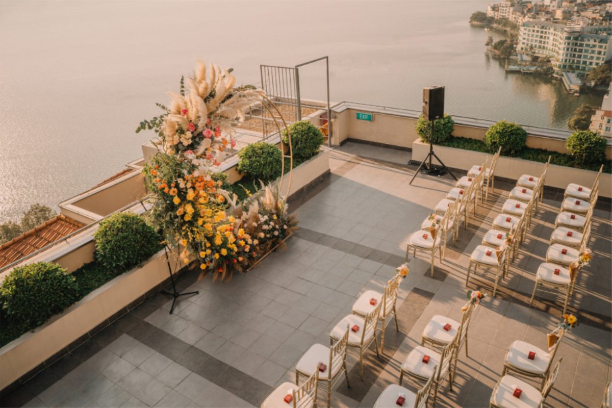 Trang trí lễ cưới ngoài trời sang trọng tại Pan Pacific Hanoi với hoa tone rực rỡ và ghế vàng ánh kim. (Ảnh: TIFF.vn)
