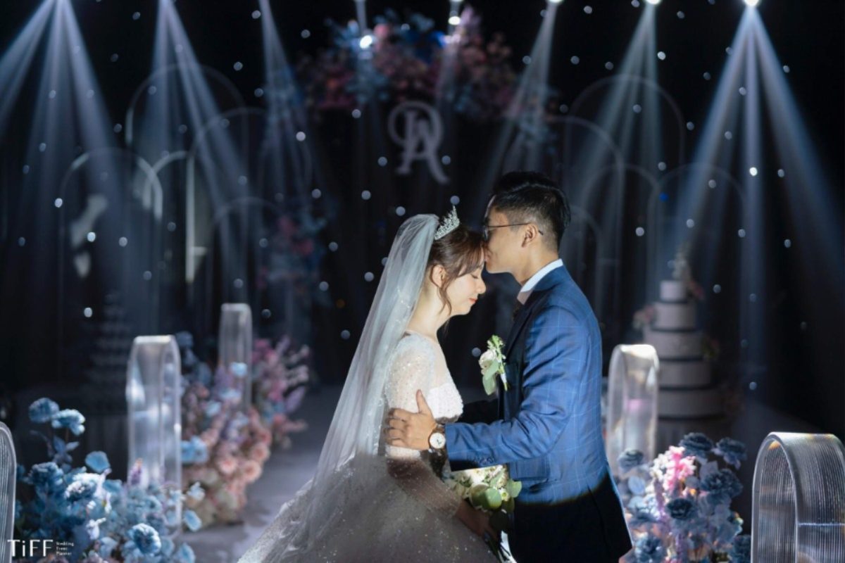 Khu vực lễ cưới tại Grand Plaza Hanoi lãng mạn, nơi chú rể trao nụ hôn lên trán cô dâu, được trang trí bằng hoa tươi và ánh nến lung linh (Ảnh: TIFF.vn) 