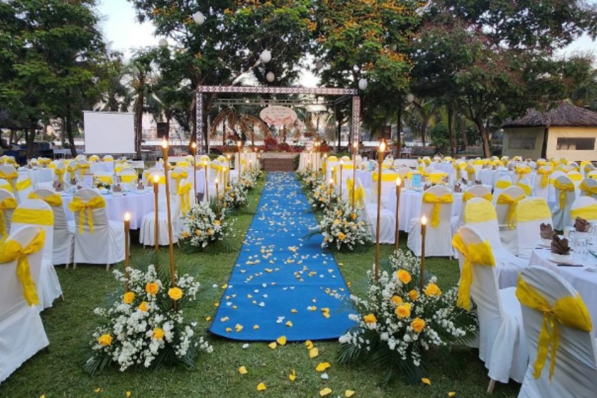 Sân cỏ rộng, cổng cưới tre – hoa lá, ghế trắng đơn giản. (Ảnh: Sưu tầm)