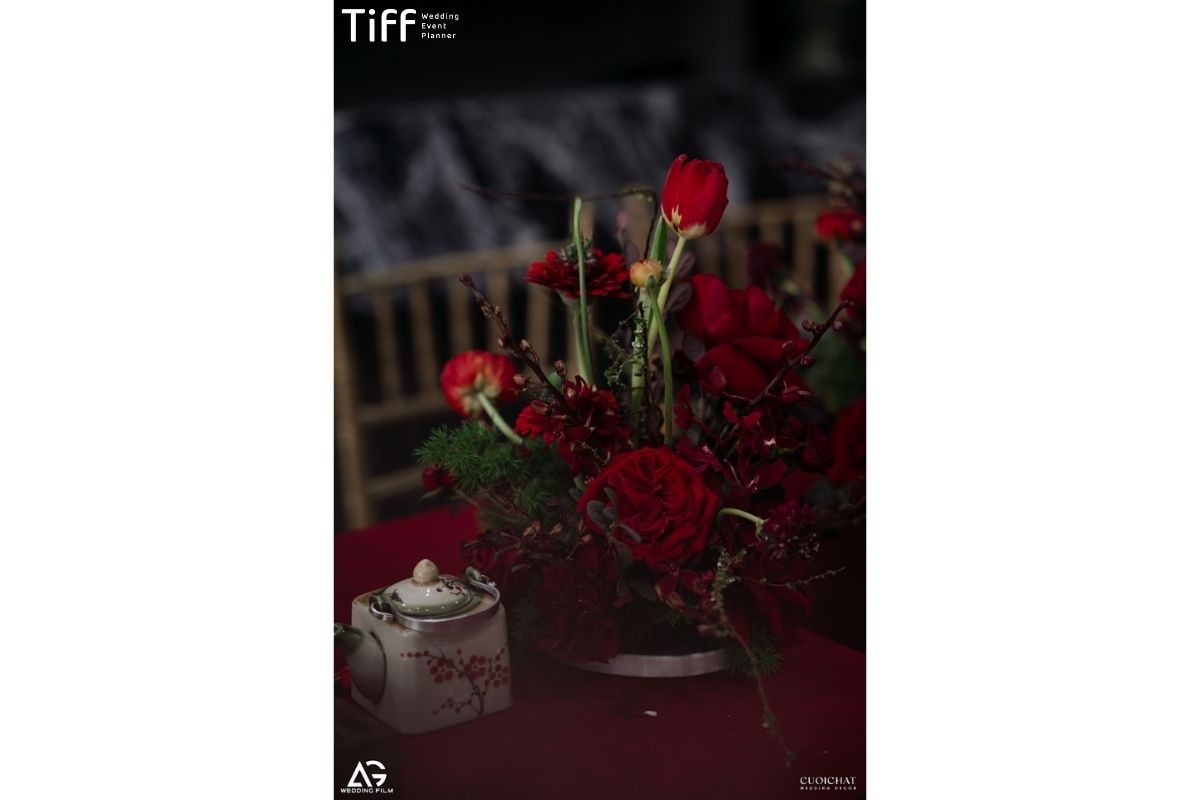 Cụm hoa tông đỏ chủ đạo, kết hợp ấm trà cổ cho bàn trà cưới (Ảnh: TIFF)